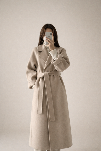 Manteau long beige à col revers, ceinture nouée, silhouette ajustée