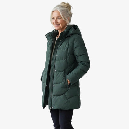 Manteau matelassé vert foncé à capuche, fermeture zippée, poches latérales et boutons.