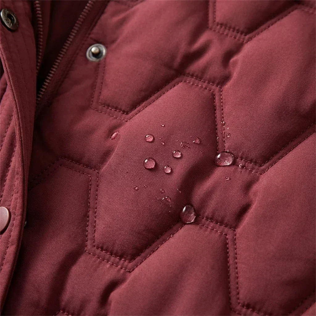 Manteau long imperméable matelassé bordeaux, gouttes d’eau sur losanges et surpiqûres.