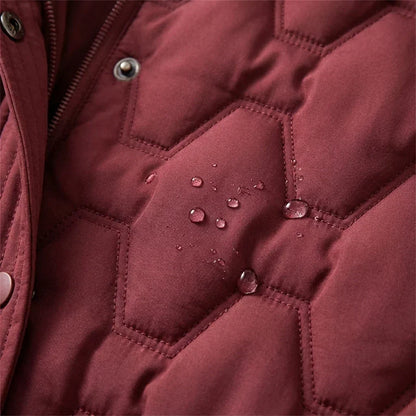 Manteau long imperméable matelassé bordeaux, gouttes d’eau sur losanges et surpiqûres.