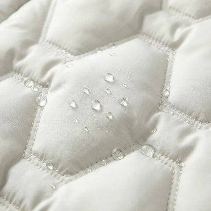 Manteau long imperméable blanc matelassé, gouttes d’eau sur la surface et surpiqûres.