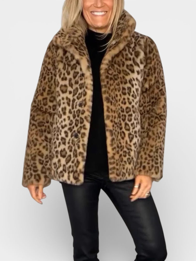 Manteau léopard kaki long, col châle et patte boutonnée, porté avec pantalon noir.