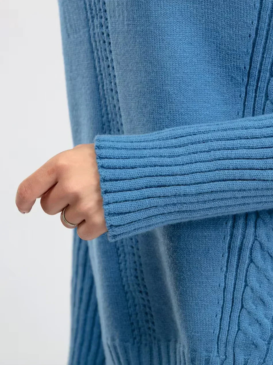Manche et bas de pull en maille bleu, côtes et texture torsadée au poignet.