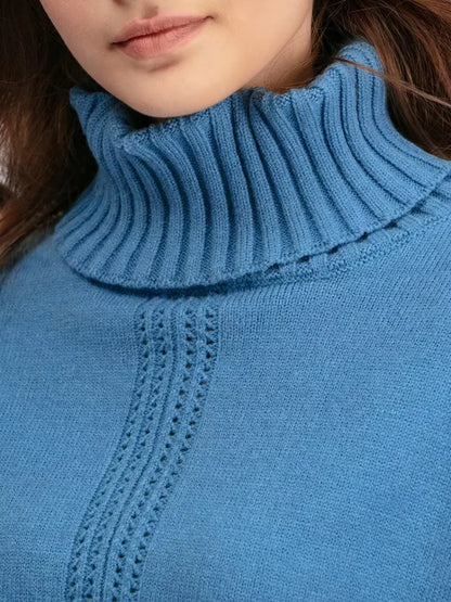 Col roulé en tricot bleu avec fines côtes et empiècement ajouré au niveau du buste.