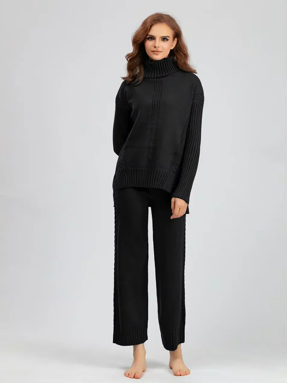Ensemble tricot noir : pull col montant zippé et pantalon long à côtes, coupe droite.