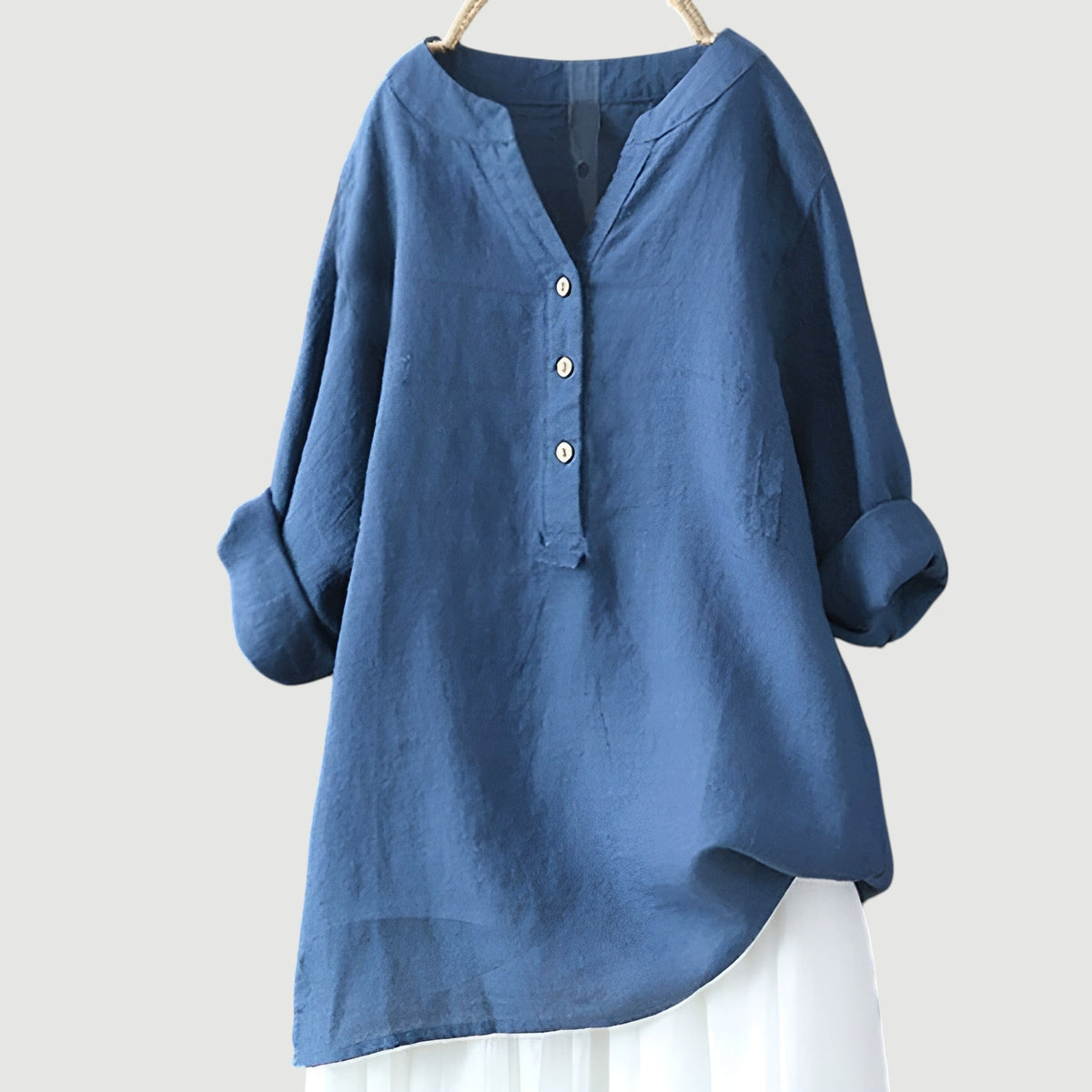 Chemise ample en lin bleu, encolure en V, patte boutonnée, manches larges.