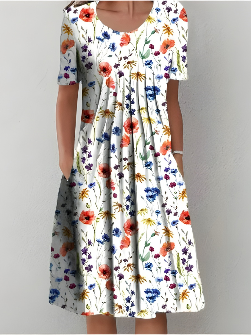 Robe plissée fleurie blanche, fleurs multicolores, manches courtes, encolure ronde.