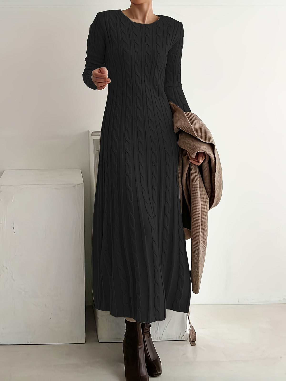 Robe en maille noire à torsades, manches longues, col rond, coupe mi-longue.