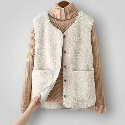 Gilet polaire douillet beige clair, col montant côtelé, boutonné, poches sur le devant.
