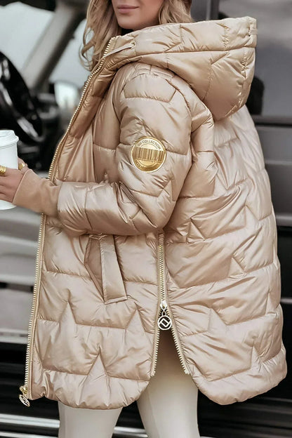 Manteau matelassé beige à capuche, fermeture zippée, poches et badge sur la manche.