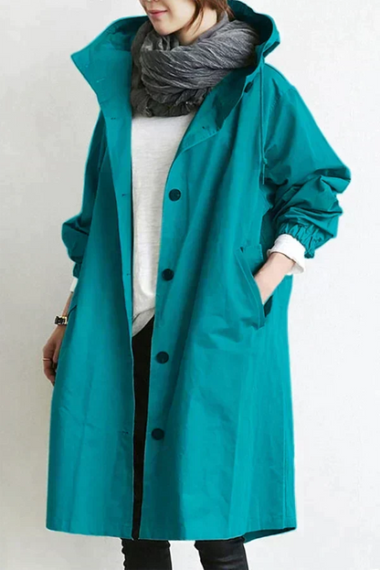 Trench-coat déperlant bleu turquoise à capuche, boutons noirs et manches froncées