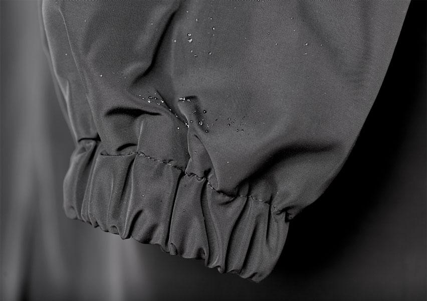 Poignet froncé d’un trench-coat gris anthracite, avec gouttes visibles au tissu