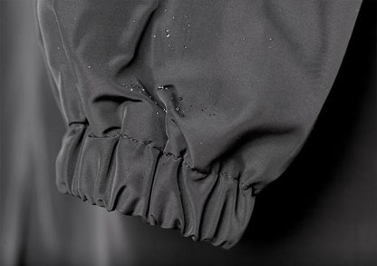 Poignet froncé d’un trench-coat gris anthracite, avec gouttes visibles au tissu