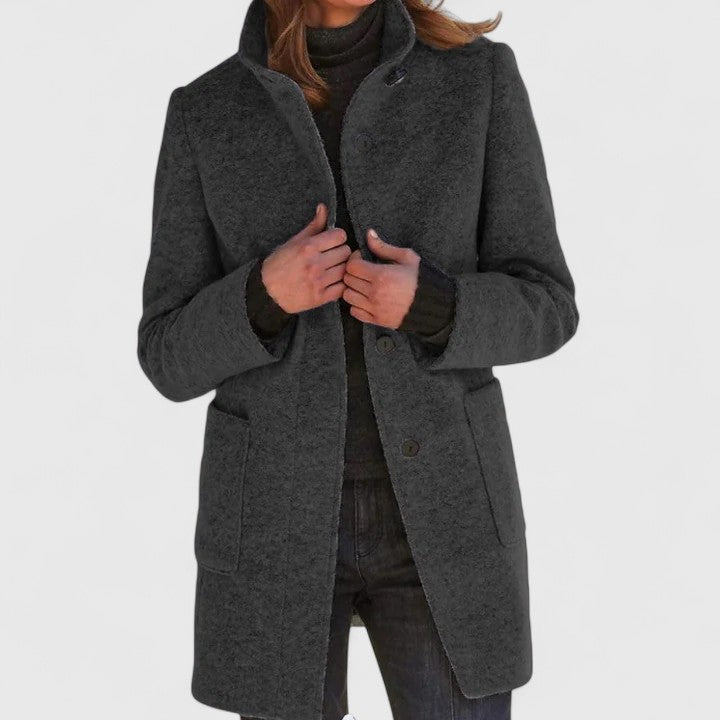 Manteau en laine gris foncé à boutons, col revers et poches plaquées, coupe droite.