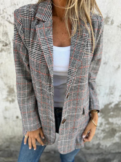 Manteau à carreaux gris et rouges, col tailleur, fermeture boutonnée, manches longues.
