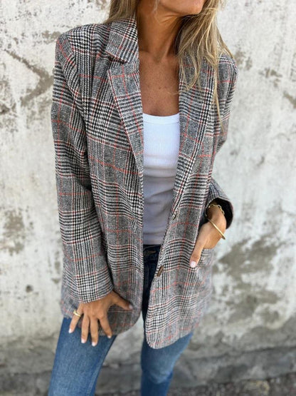 Manteau à carreaux gris et rouge, col tailleur, coupe droite, poignets boutonnés.