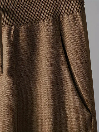 Détail tissu : maille marron avec bord-côtes en haut du pantalon.