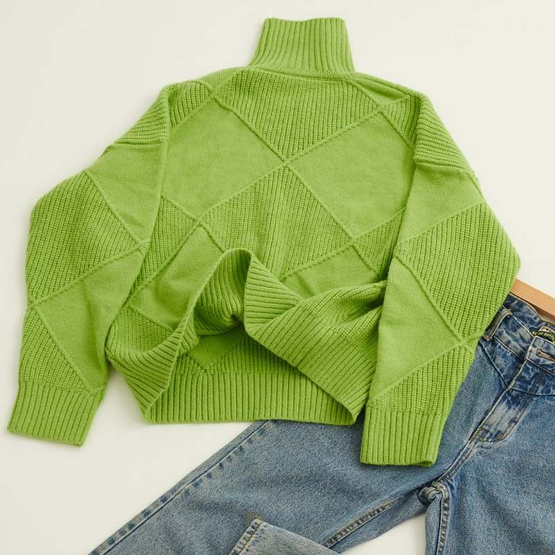 Pull en tricot vert à col roulé, motifs torsadés en losanges, posé à plat