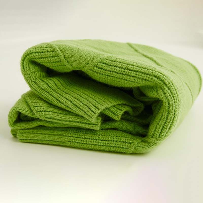 Pli de pull en tricot vert, maille épaisse côtelée, vue pliée