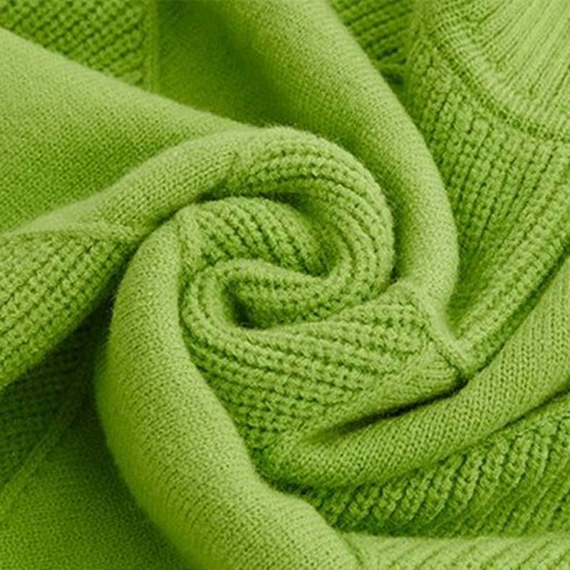 Détail du pull en tricot vert : maille texturée et couture de bord