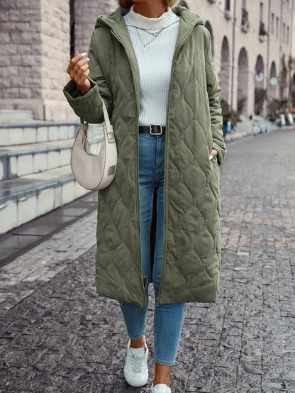 Manteau long matelassé vert à capuche, fermeture zippée, coutures visibles, poches.
