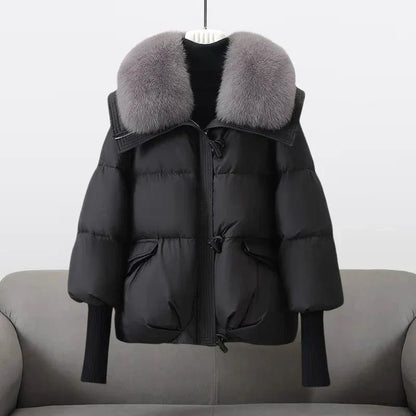 Manteau matelassé noir à capuche bordée de fourrure, zip et lien à la taille.