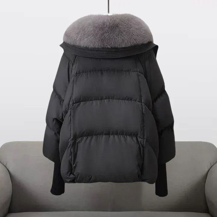 Manteau matelassé noir à capuche bordée de fourrure et poches plaquées.