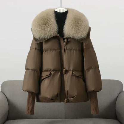 Manteau matelassé marron à capuche bordée de fourrure, zip et poches à rabat.