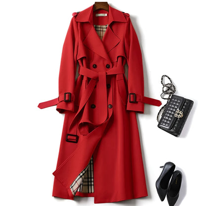 Trench-coat rouge à col pointu, ceinture à boucles, boutons noirs, doublure à carreaux.