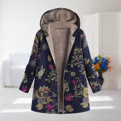 Veste à capuche doublée polaire, motif floral sur fond bleu foncé, fermeture zippée.
