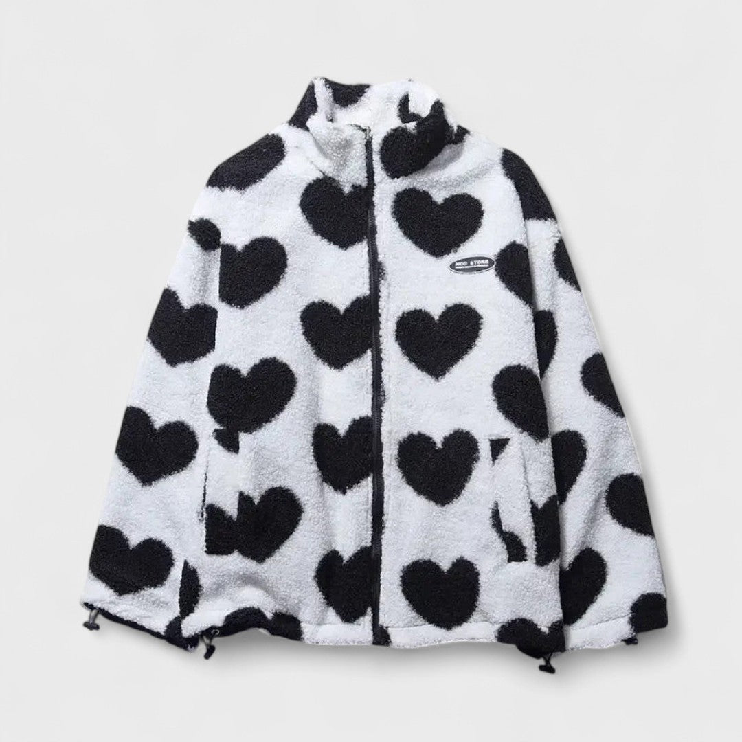 Veste réversible en polaire à cœurs noir sur fond blanc, fermeture zippée, col montant.