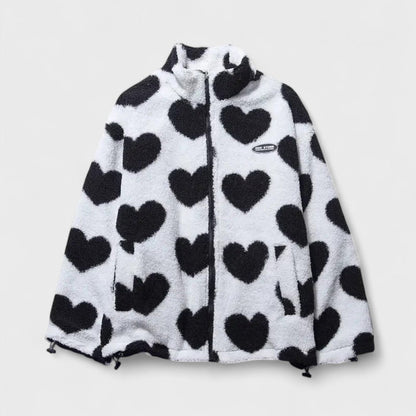 Veste réversible en polaire à cœurs noir sur fond blanc, fermeture zippée, col montant.