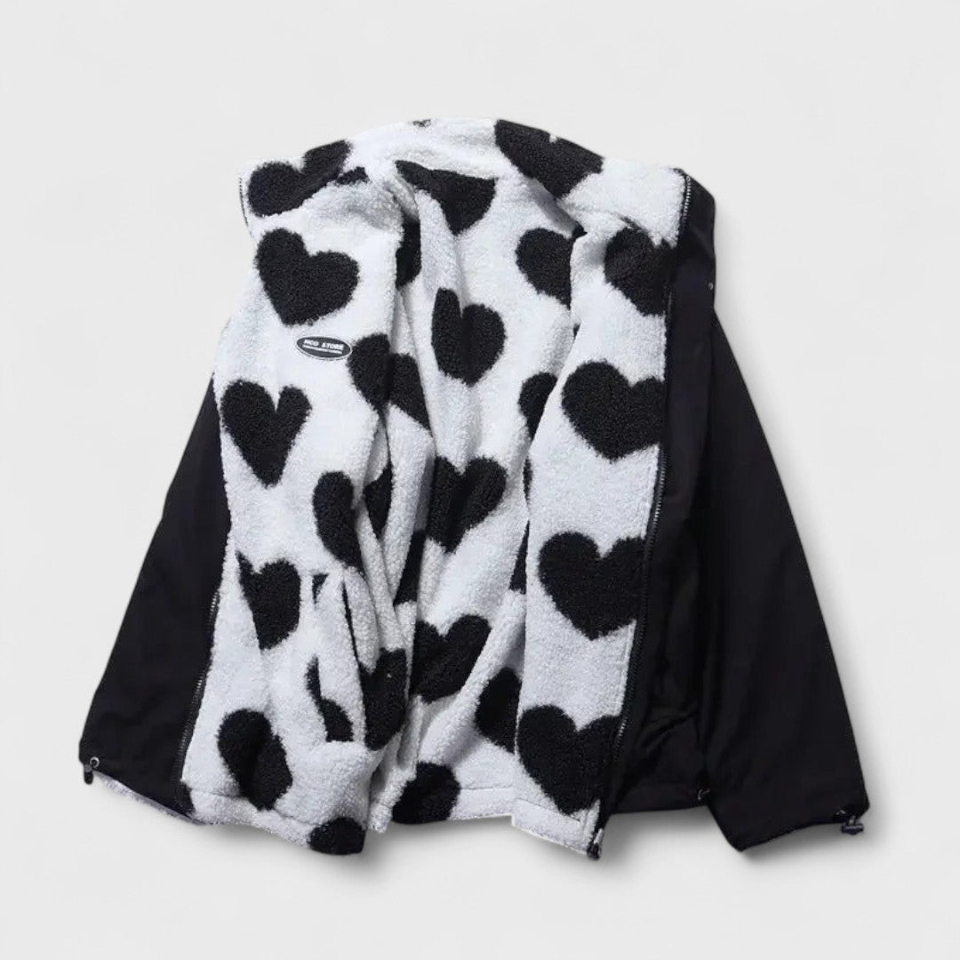 Veste réversible : face polaire à cœurs noir et blanc, revers en tissu noir.