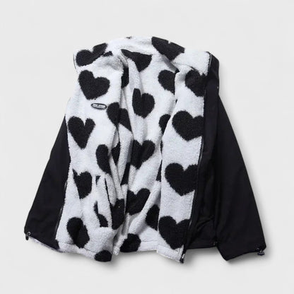 Veste réversible : face polaire à cœurs noir et blanc, revers en tissu noir.