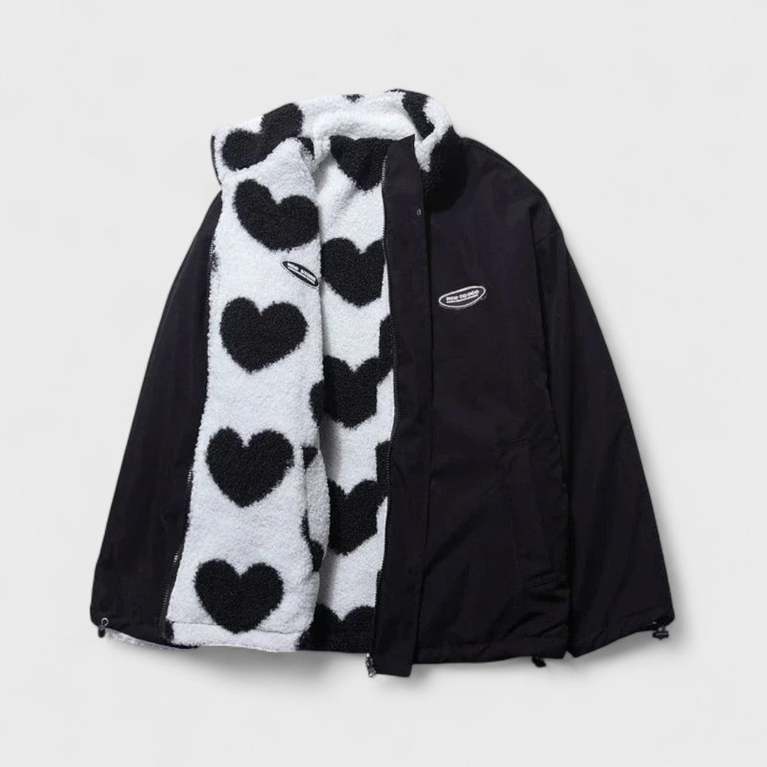 Veste réversible : face polaire à cœurs noir et blanc, revers en tissu noir.