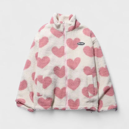 Veste réversible en polaire à cœurs rose, fond clair, fermeture zippée, col montant.