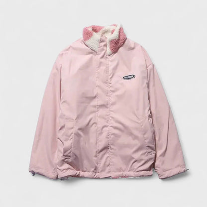 Veste réversible avec face rose unie et col/panneau en polaire à cœurs roses.