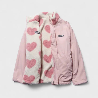 Veste réversible avec face rose unie et panneaus en polaire à cœurs roses.