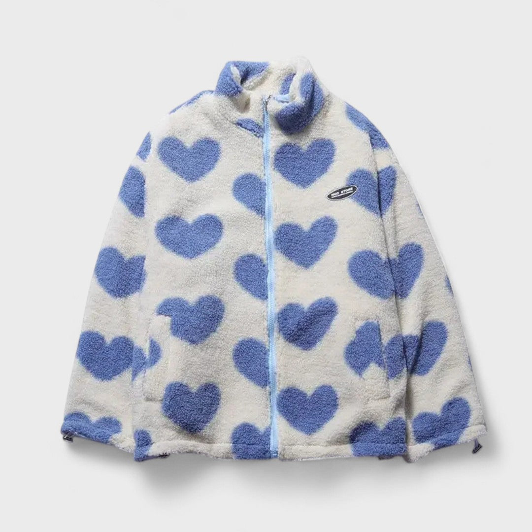 Veste réversible en polaire à cœurs bleu sur fond clair, fermeture zippée, col montant.