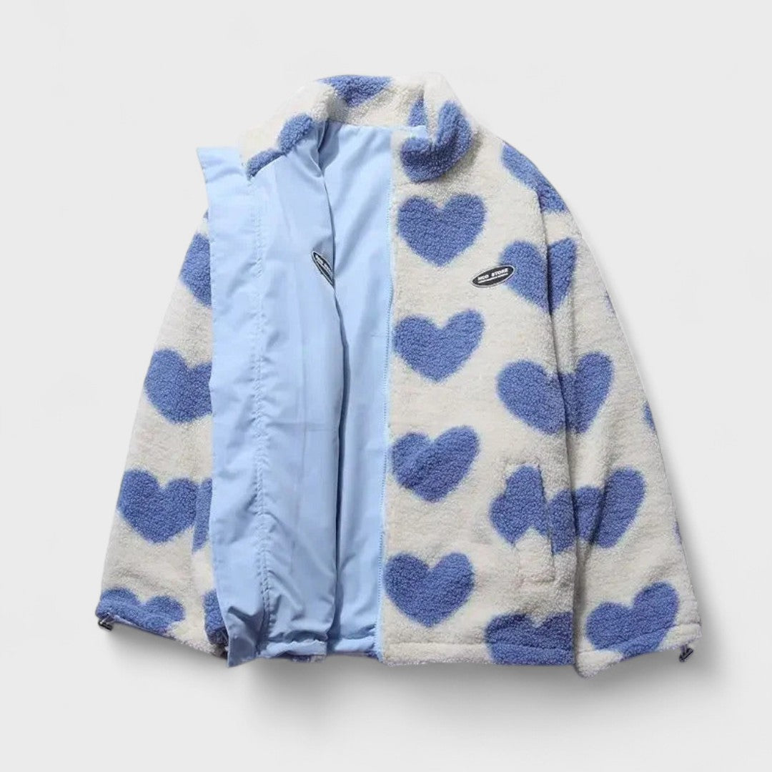 Veste réversible : face polaire à cœurs bleus, revers en tissu bleu clair, col montant.