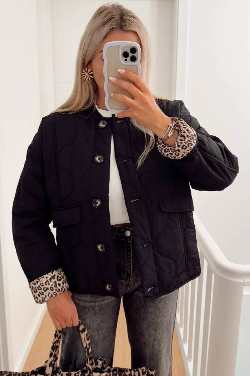 Veste matelassée noire, col droit à boutons, poches plaquées, doublure imprimée léopard