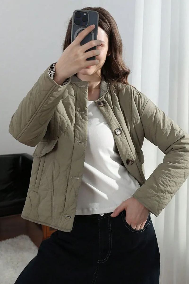 Veste matelassée vert sauge avec col droit, boutons visibles et poches plaquées