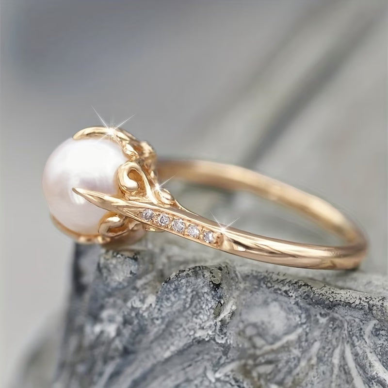 Bague dorée, perle blanche ronde et ligne de cristaux sur le dessus