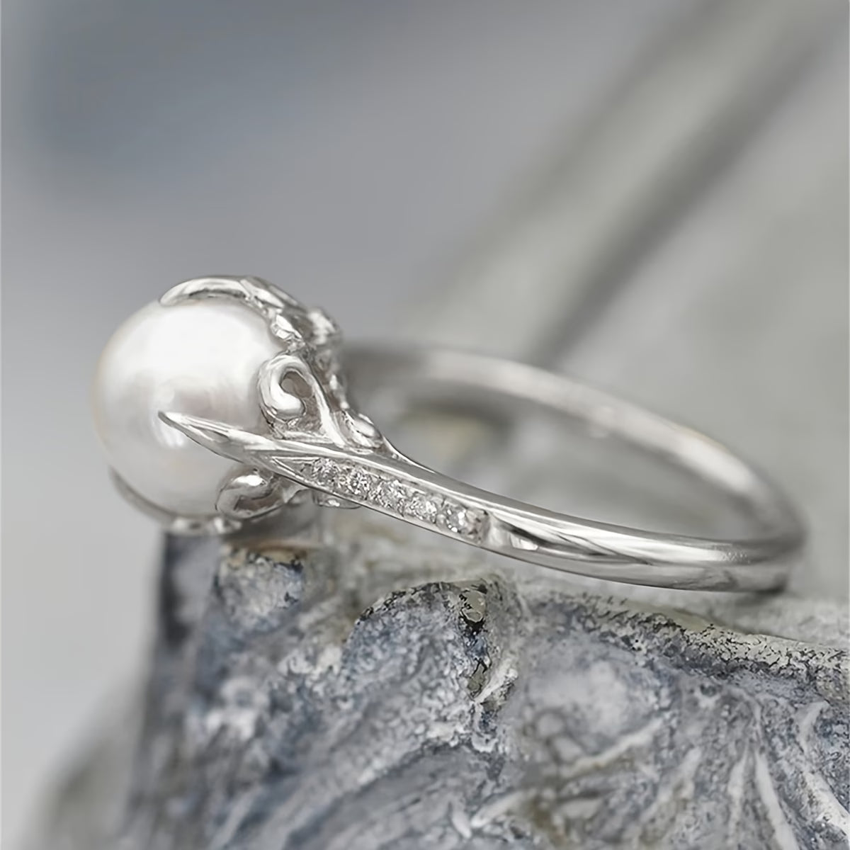 Bague argentée, perle ronde blanche et ligne de cristaux sur le dessus
