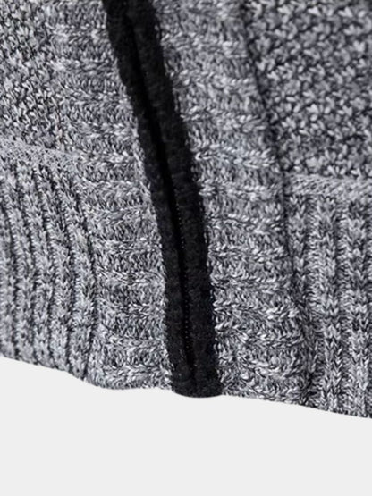 Gilet gris : bas côtelé et bordure noire, texture de maille visible.