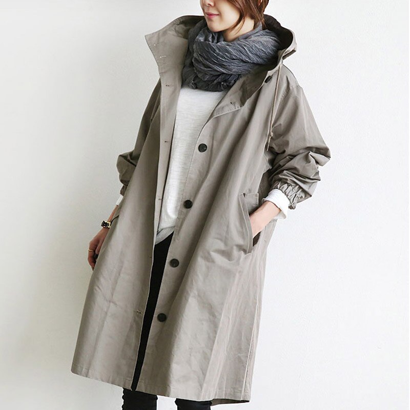 Trench-coat déperlant long beige à capuche, patte boutonnée, poche latérale.