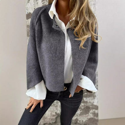 Veste courte grise à col boutonné, manches évasées sur chemise blanche