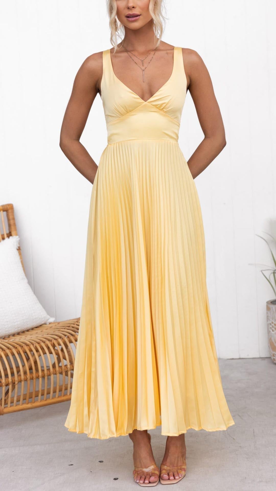 Robe longue plissée jaune à bretelles fines et décolleté croisé.