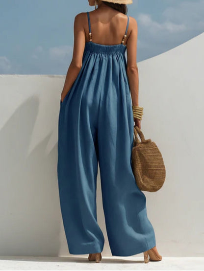 Combinaison en denim bleu ample à bretelles fines, encolure carrée, jambes larges.