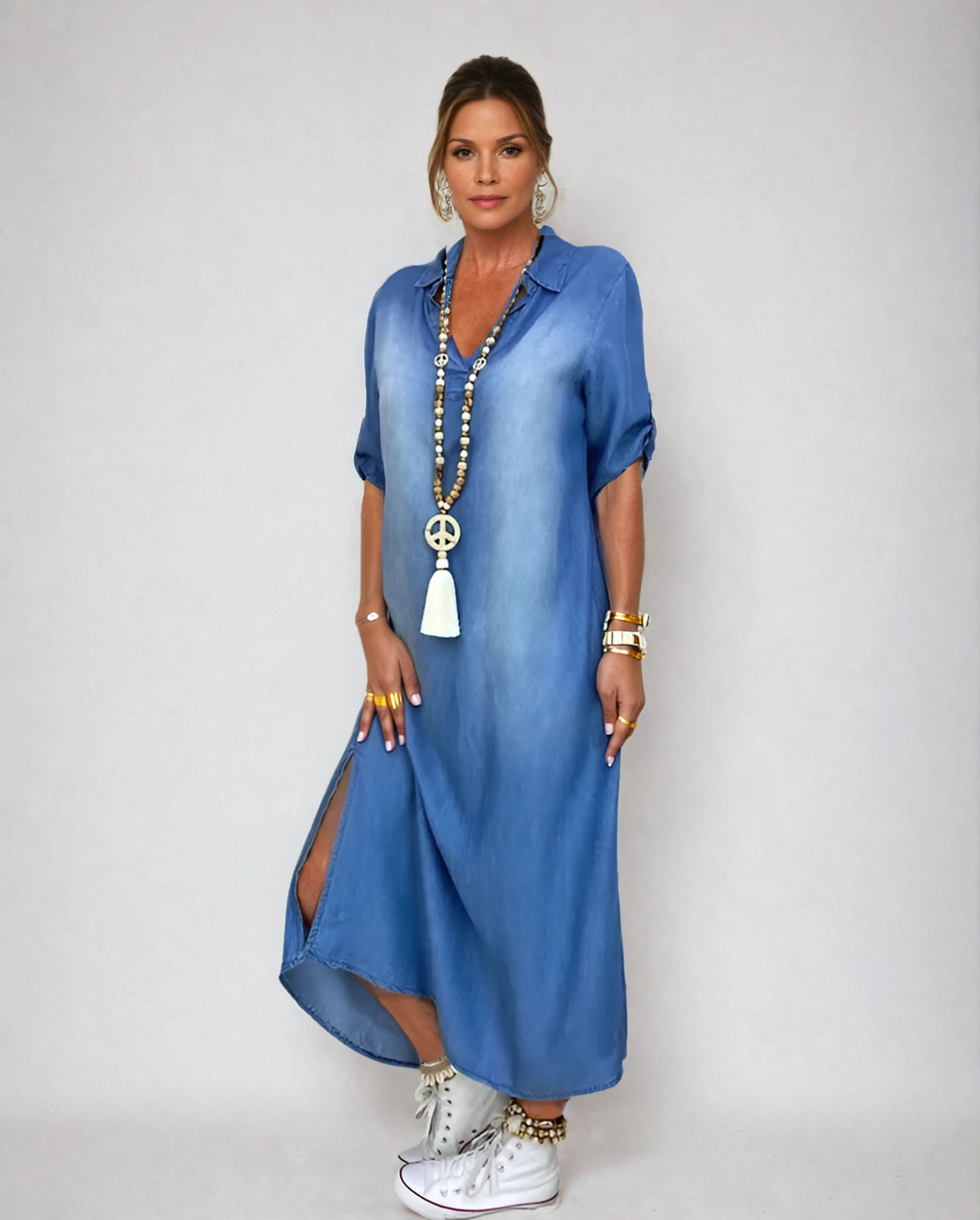 Robe longue en jean bleu, col en V, manches courtes bouffantes, fente latérale.